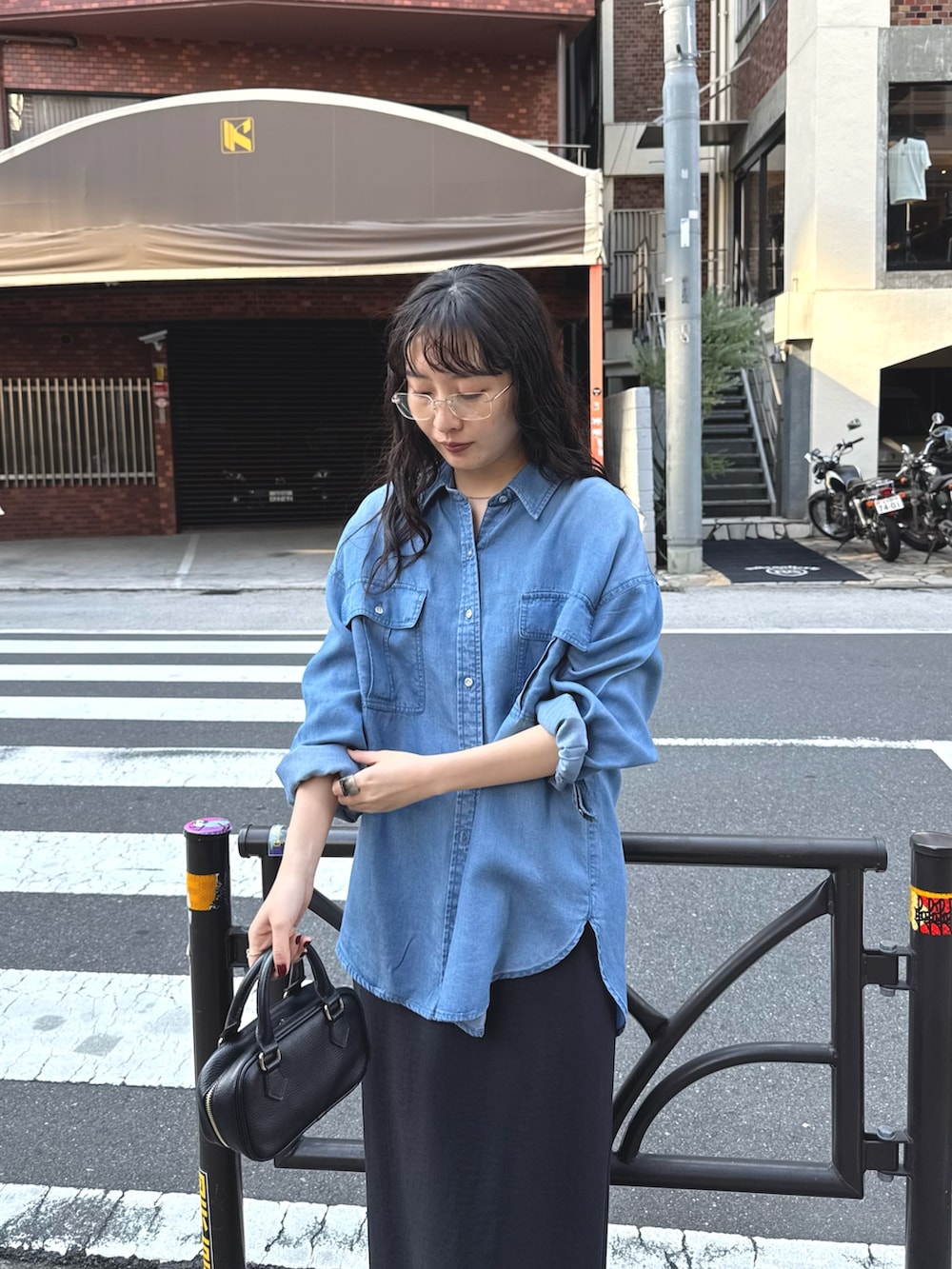 ブルー系のシャツ/ブラウス、ブラック系のスカートを着用したレディースの春コーディネートの4枚目の写真