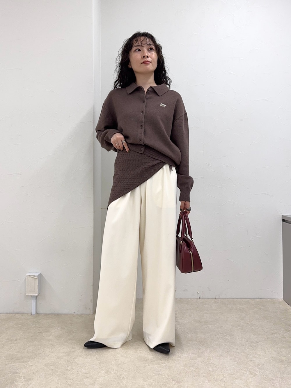 ブラウン系のニット/セーター、ホワイト系のその他パンツ、レッド系のショルダーバッグを着用したレディースの秋コーディネートの2枚目の写真