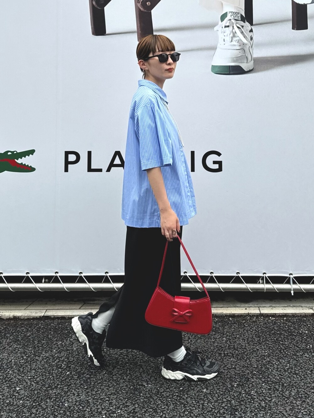 ブラック系のスカート、ブルー系のシャツ/ブラウス、ホワイト系のネックレスを着用したレディースの夏コーディネートの2枚目の写真