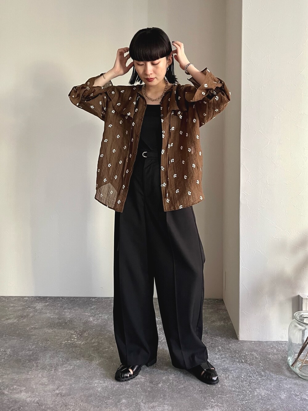 ブラウン系のシャツ/ブラウス、ブラック系のスラックス、ブラック系のサンダルを着用したレディースの夏コーディネートの2枚目の写真