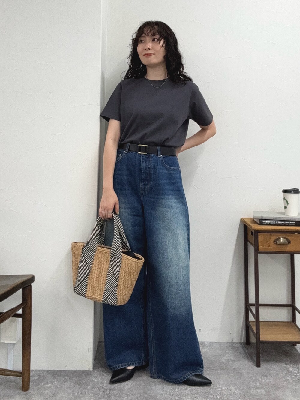 グレー系のTシャツ/カットソー、ブルー系のデニムパンツ、ベージュ系のかごバッグを着用したレディースの夏コーディネートの5枚目の写真