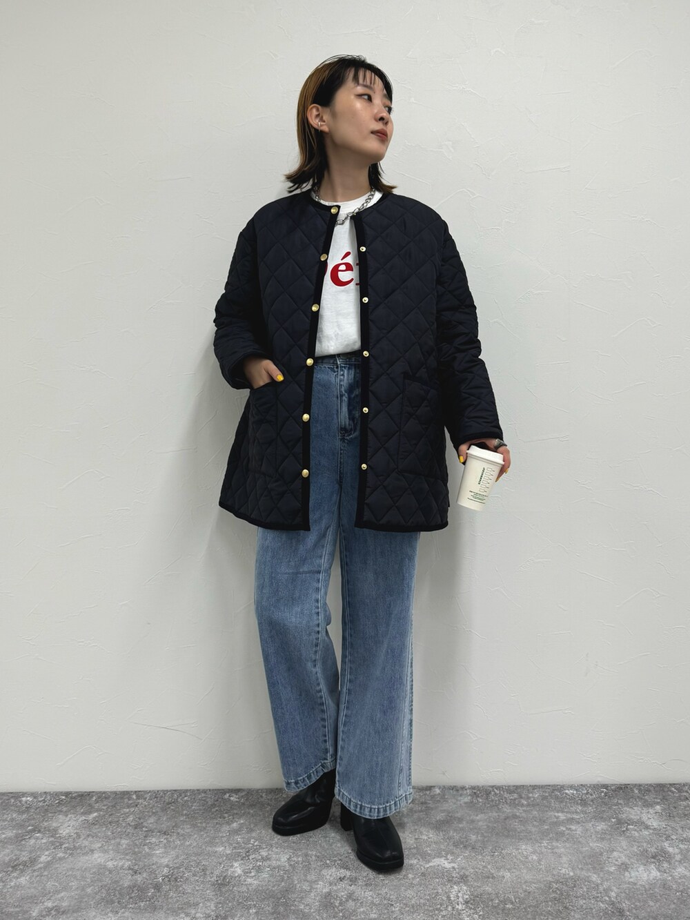 ブラック系のブルゾン、ホワイト系のTシャツ/カットソー、ブルー系のデニムパンツを着用したレディースの夏コーディネートの2枚目の写真