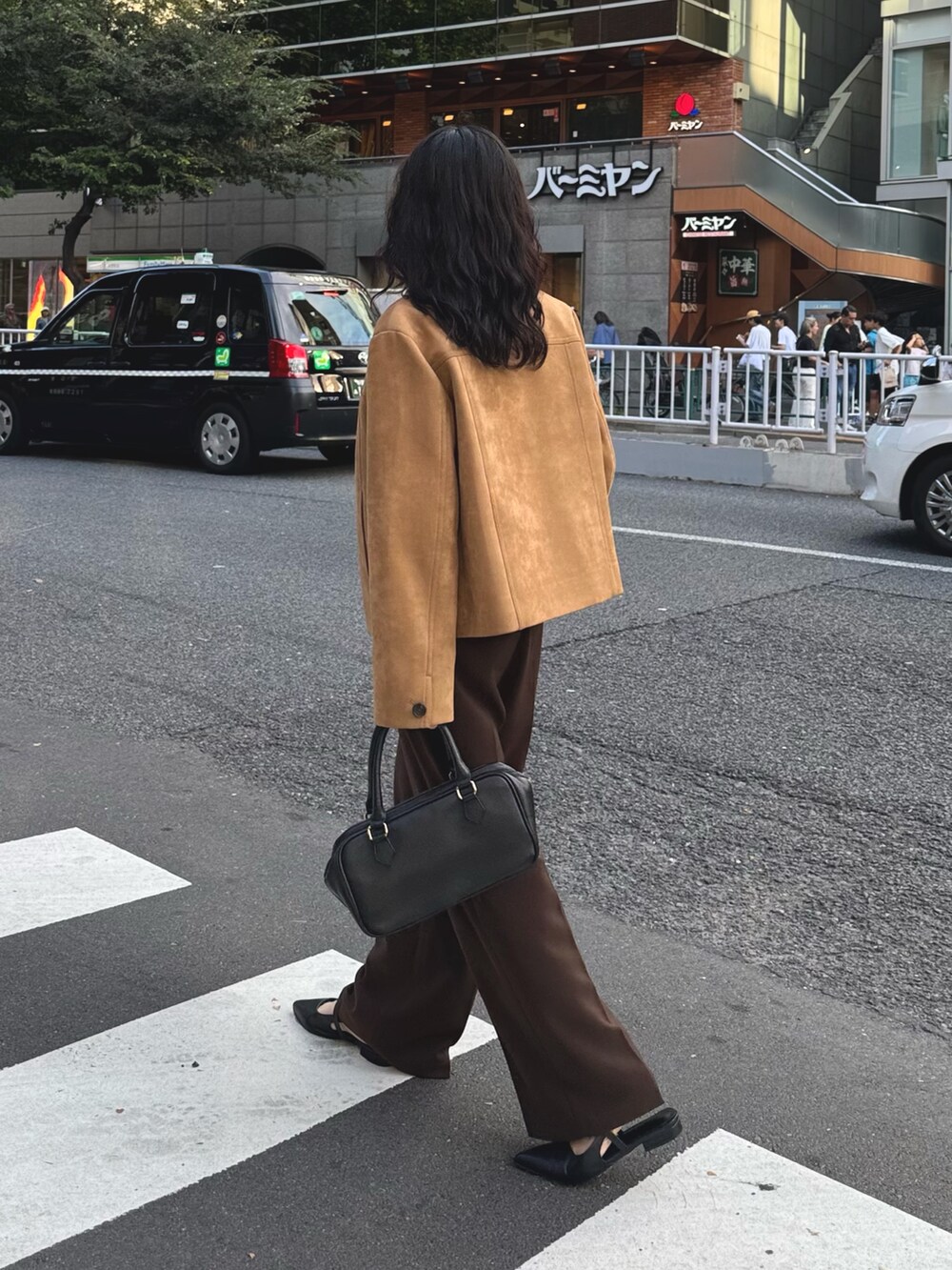 ベージュ系のダウンジャケット/コート、ホワイト系のTシャツ/カットソー、ブラウン系のスラックスを着用したレディースの秋コーディネートの6枚目の写真