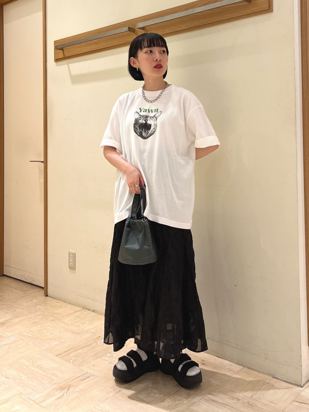 ホワイト系のTシャツ/カットソー、ブラック系のスカート、グレー系のショルダーバッグを着用したレディースの夏コーディネートの2枚目の写真