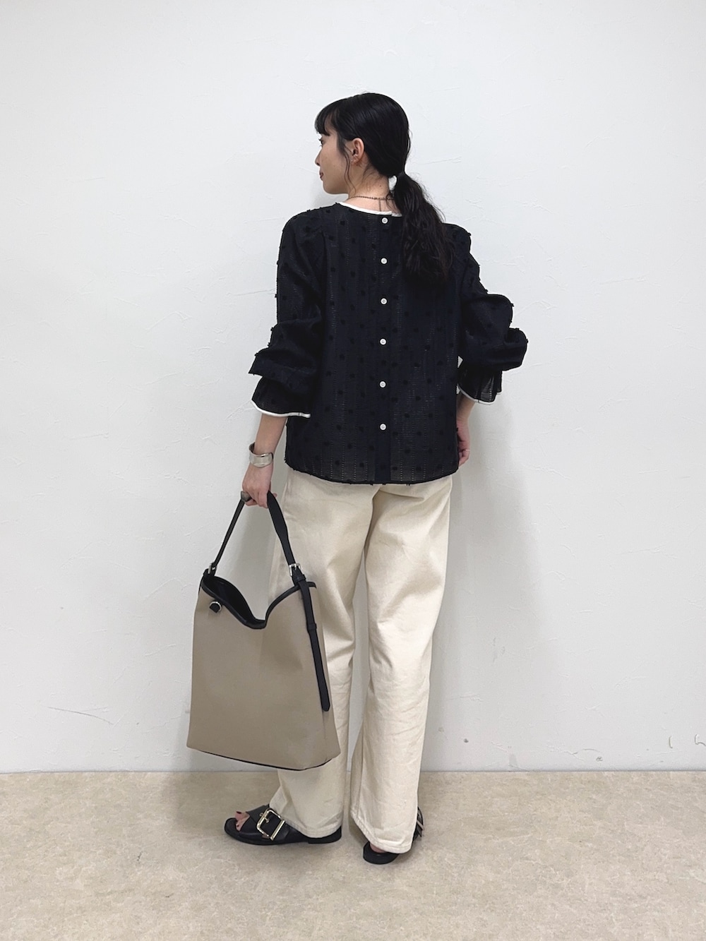 ブラック系のシャツ/ブラウス、ホワイト系のデニムパンツ、ブラック系のショルダーバッグを着用したレディースの春コーディネートの4枚目の写真