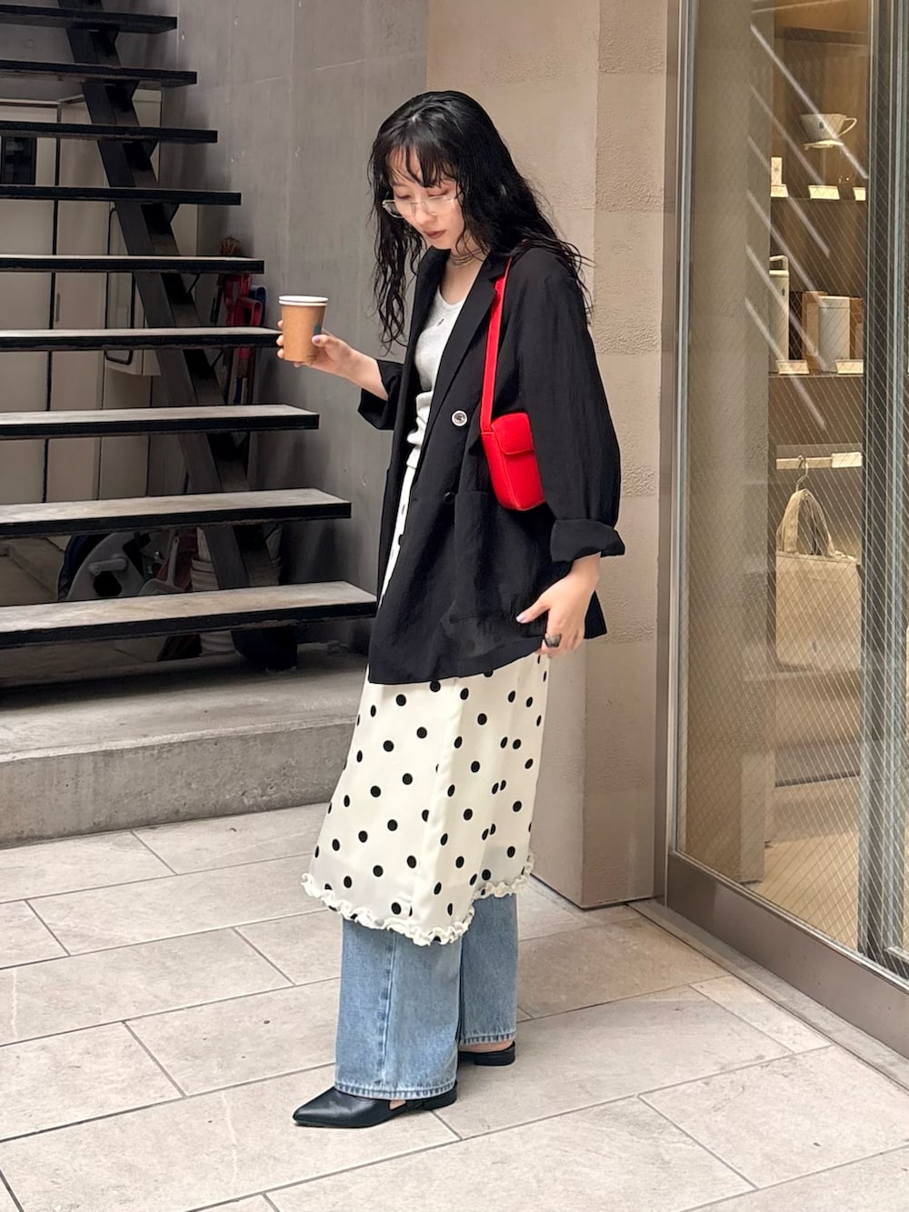 ホワイト系のスカート、ブルー系のデニムパンツ、レッド系のショルダーバッグを着用したレディースの春コーディネートの2枚目の写真