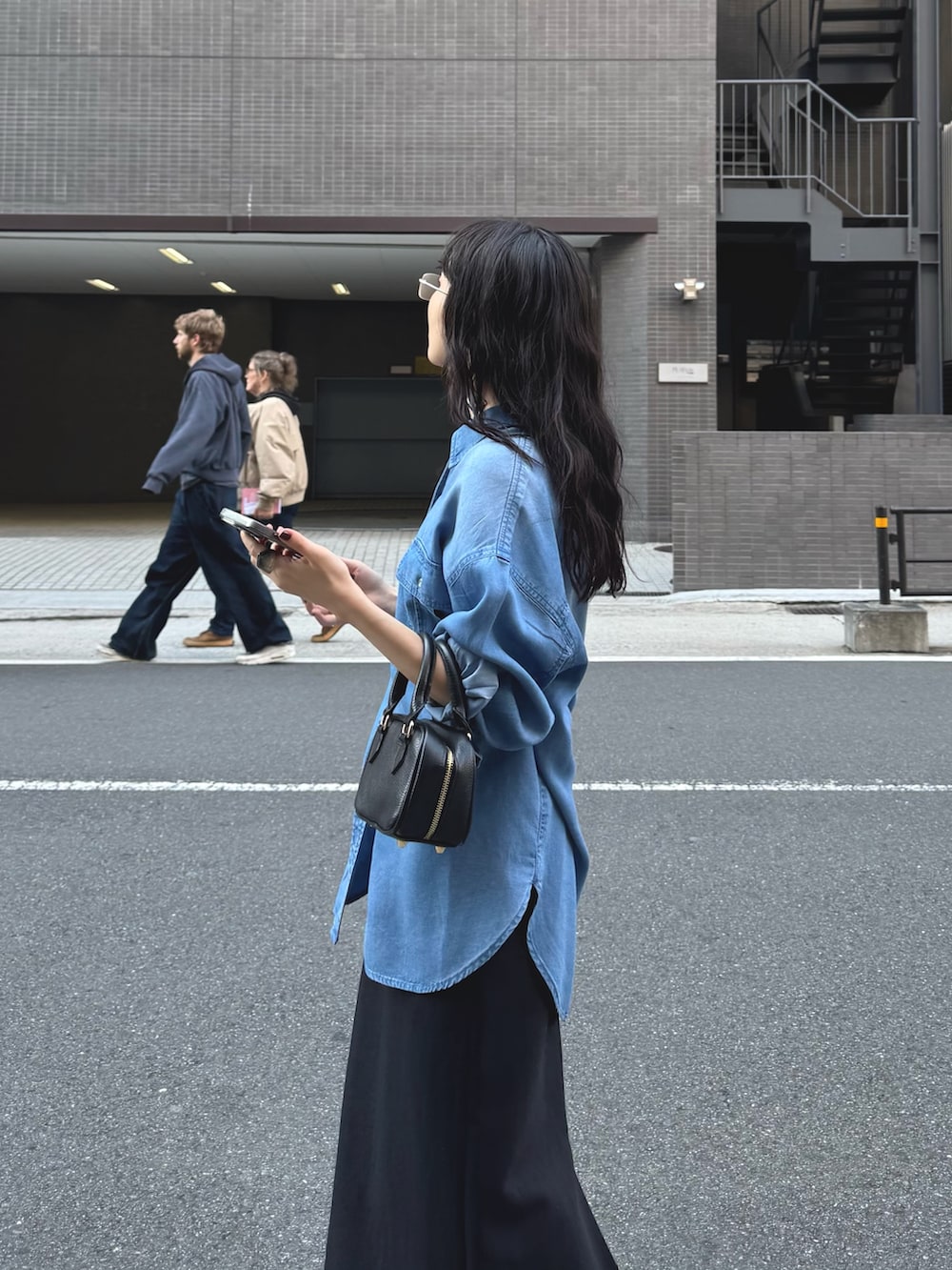 ブルー系のシャツ/ブラウス、ブラック系のスカートを着用したレディースの春コーディネートの3枚目の写真