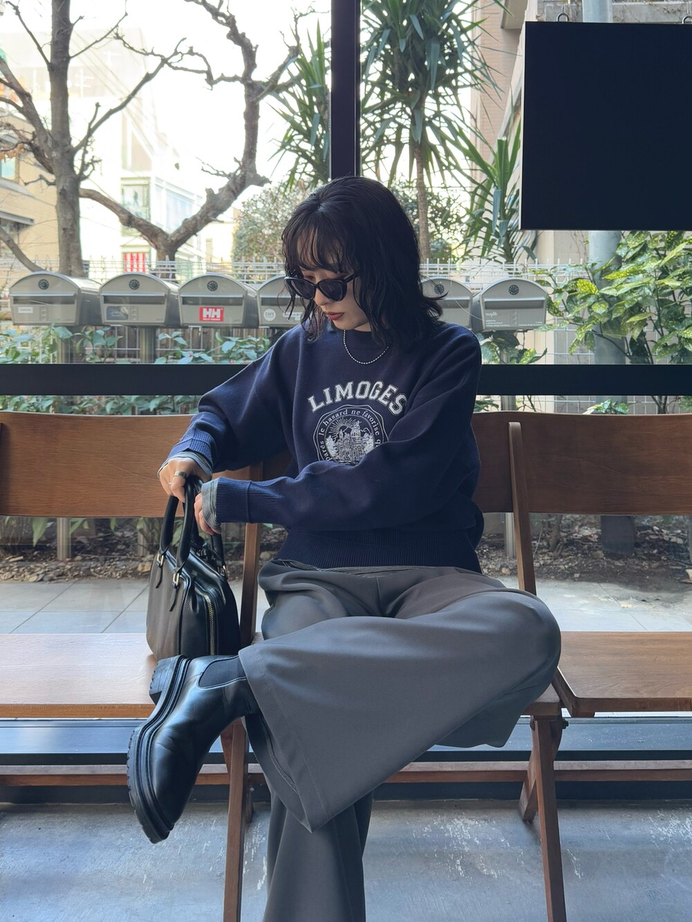 ブルー系のニット/セーター、グレー系のその他パンツ、ブラック系のハンドバッグを着用したレディースの冬コーディネートの5枚目の写真