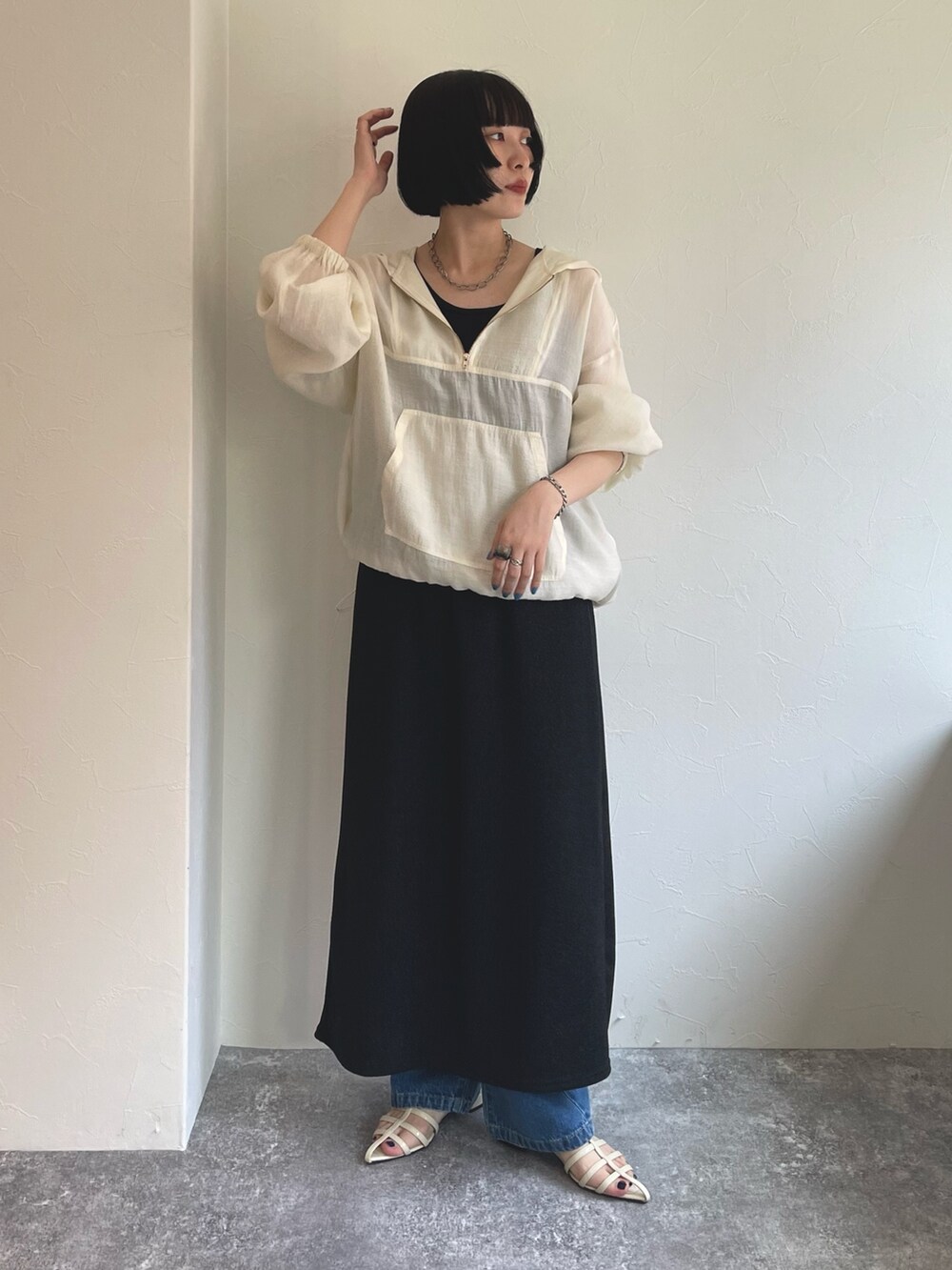 ホワイト系のブルゾン、ブラック系のタンクトップ、ブラック系のスカートを着用したレディースの春コーディネートの2枚目の写真