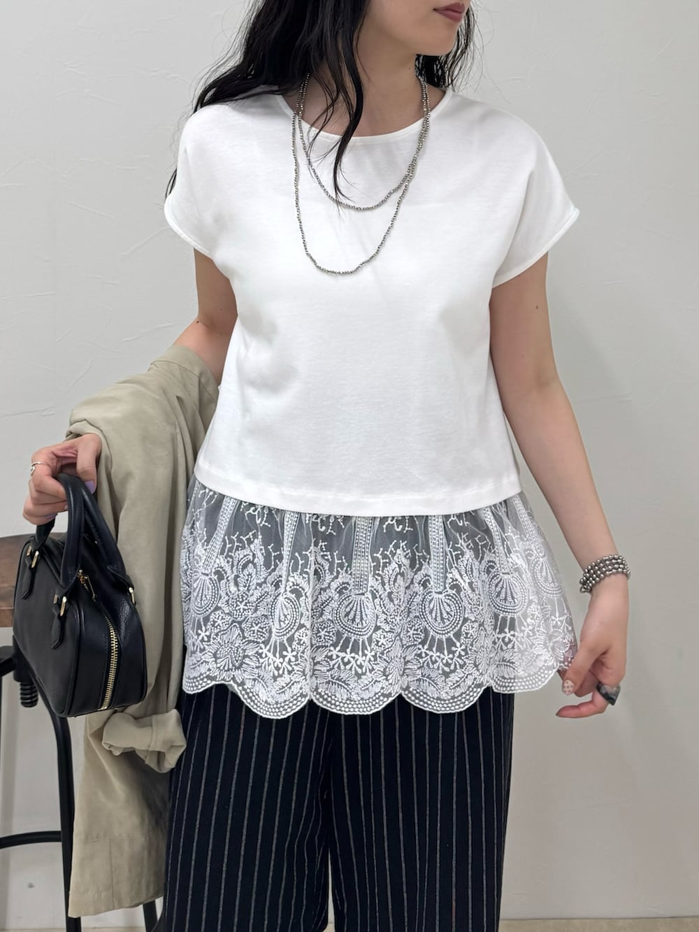 ブラック系のその他パンツ、ブラック系のサンダル、ホワイト系のTシャツ/カットソーを着用したレディースの春コーディネートの5枚目の写真