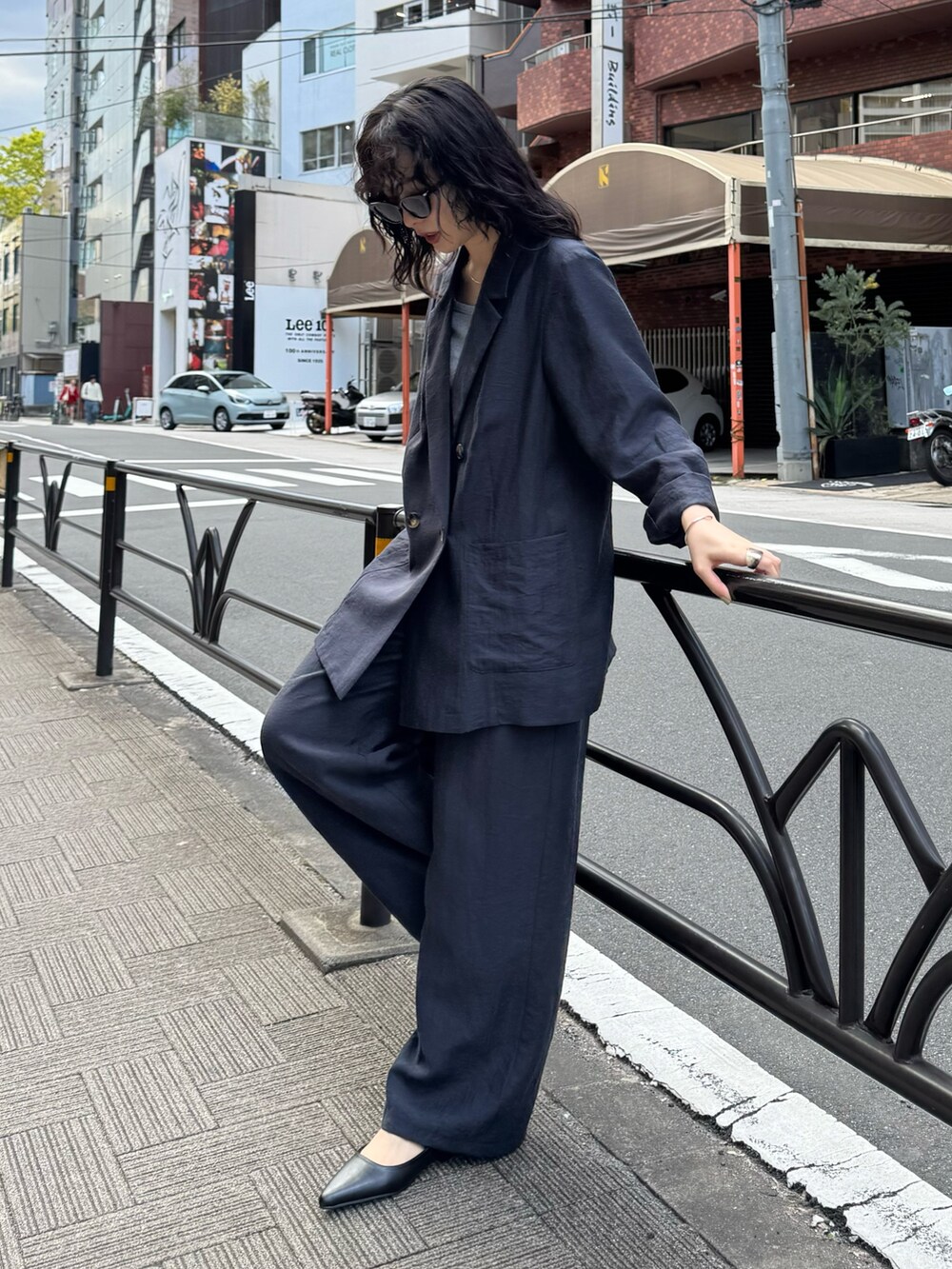 ブルー系のテーラードジャケット、ブルー系のその他パンツ、ブラック系のショルダーバッグを着用したレディースの春コーディネートの7枚目の写真