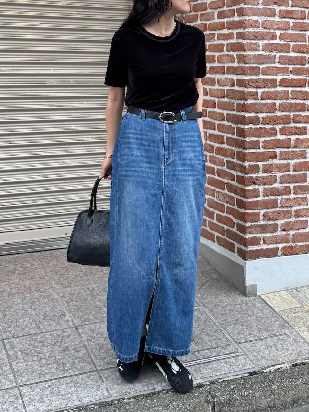 ブラック系のTシャツ/カットソー、ブルー系のデニムスカート、ブラック系のショルダーバッグを着用したレディースの夏コーディネートの4枚目の写真