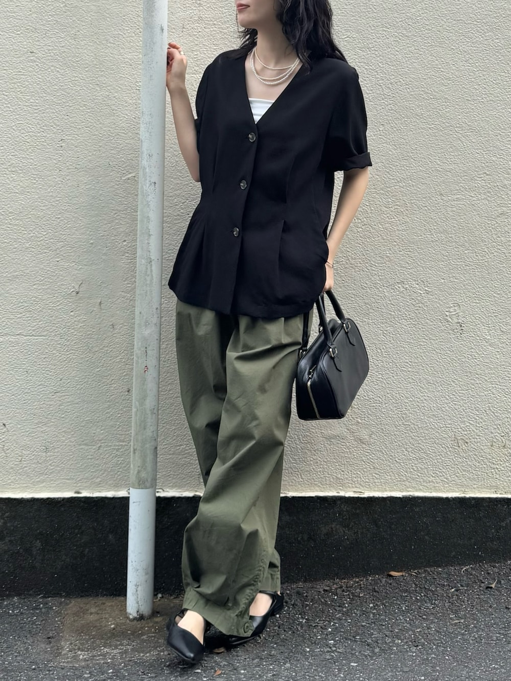 ブラック系のテーラードジャケット、グリーン系のその他パンツ、ブラック系のショルダーバッグを着用したレディースの春コーディネートの6枚目の写真