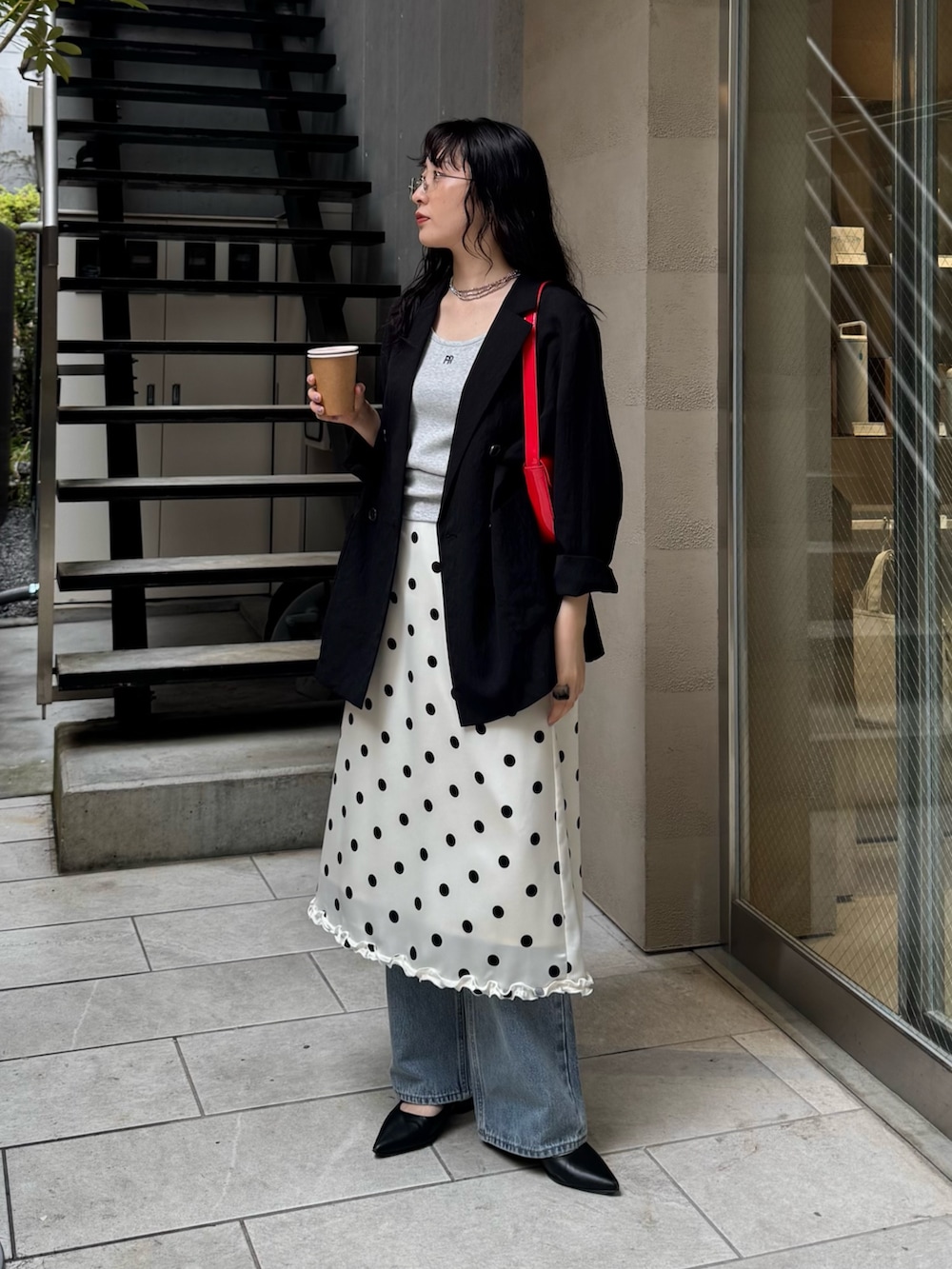 ホワイト系のスカート、ブルー系のデニムパンツ、レッド系のショルダーバッグを着用したレディースの春コーディネートの6枚目の写真