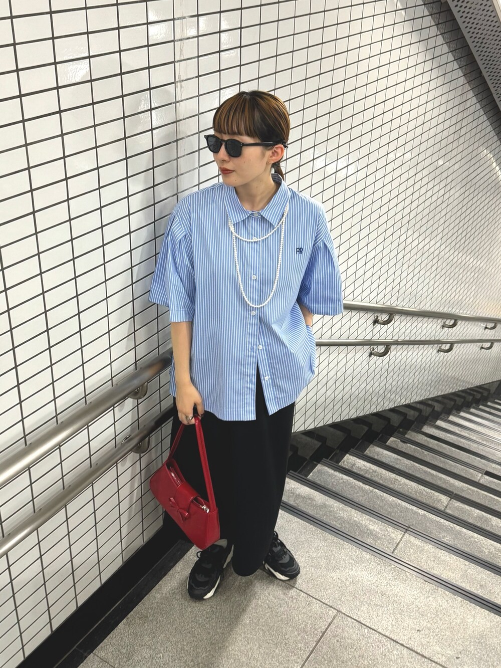 ブラック系のスカート、ブルー系のシャツ/ブラウス、ホワイト系のネックレスを着用したレディースの夏コーディネートの6枚目の写真