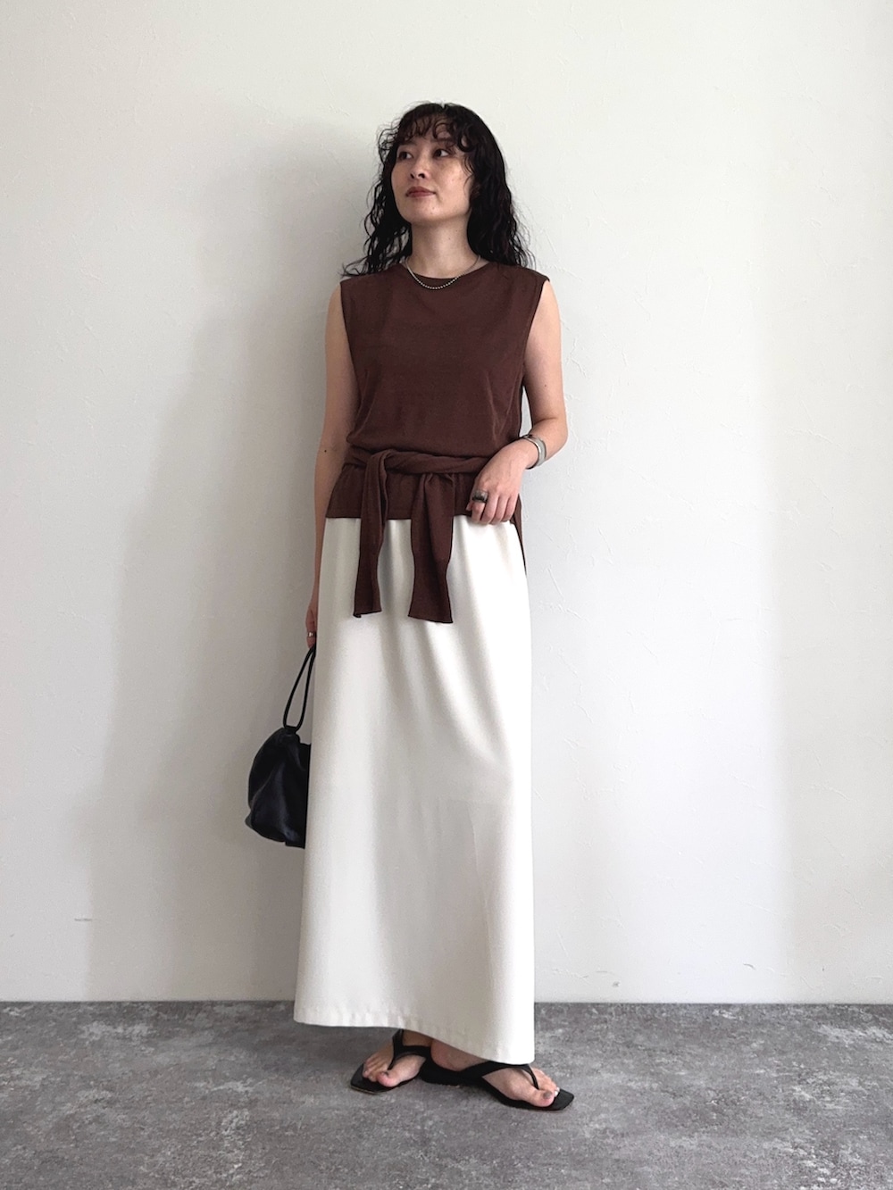 ブラウン系のタンクトップ、ブラウン系のカーディガン/ボレロ、ホワイト系のスカートを着用したレディースの夏コーディネートの6枚目の写真