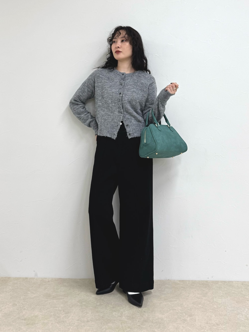 グレー系のカーディガン/ボレロ、グリーン系のショルダーバッグ、ブルー系のデニムパンツを着用したレディースの秋コーディネートの2枚目の写真