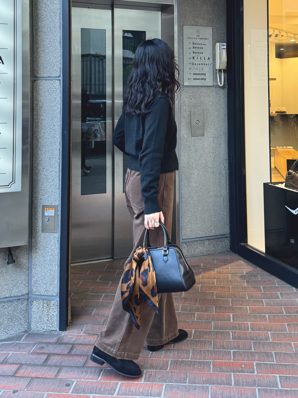 ブラック系のカーディガン/ボレロ、ブラウン系のその他パンツ、ブラック系のショルダーバッグを着用したレディースの秋コーディネートの4枚目の写真