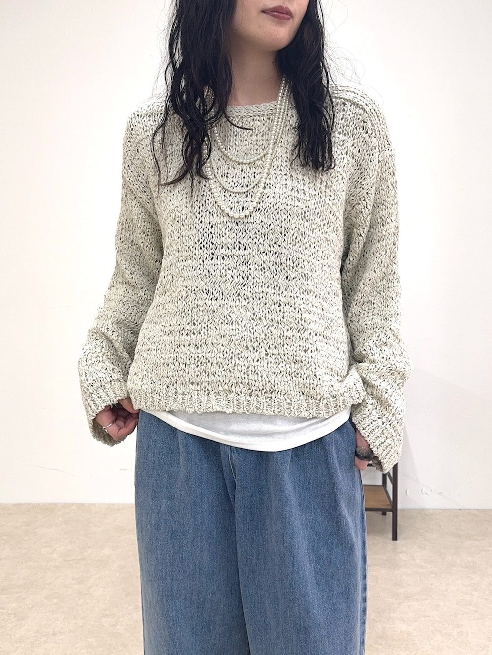 ベージュ系のニット/セーター、ホワイト系のTシャツ/カットソー、ブルー系のデニムパンツを着用したレディースの春コーディネートの4枚目の写真