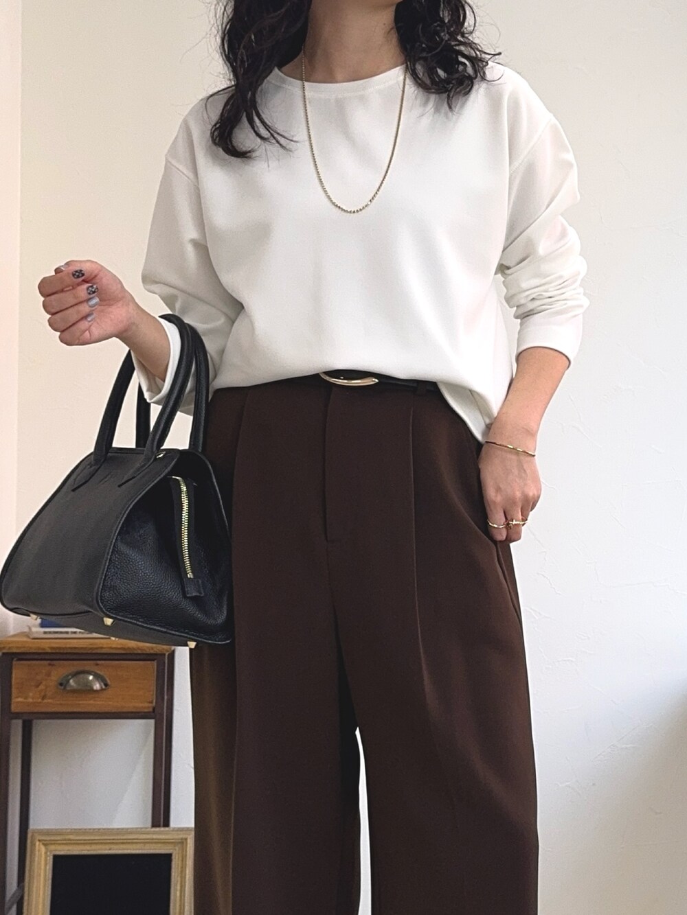 ホワイト系のTシャツ/カットソー、ブラック系のショルダーバッグ、ブラウン系のスラックスを着用したレディースの夏コーディネートの5枚目の写真