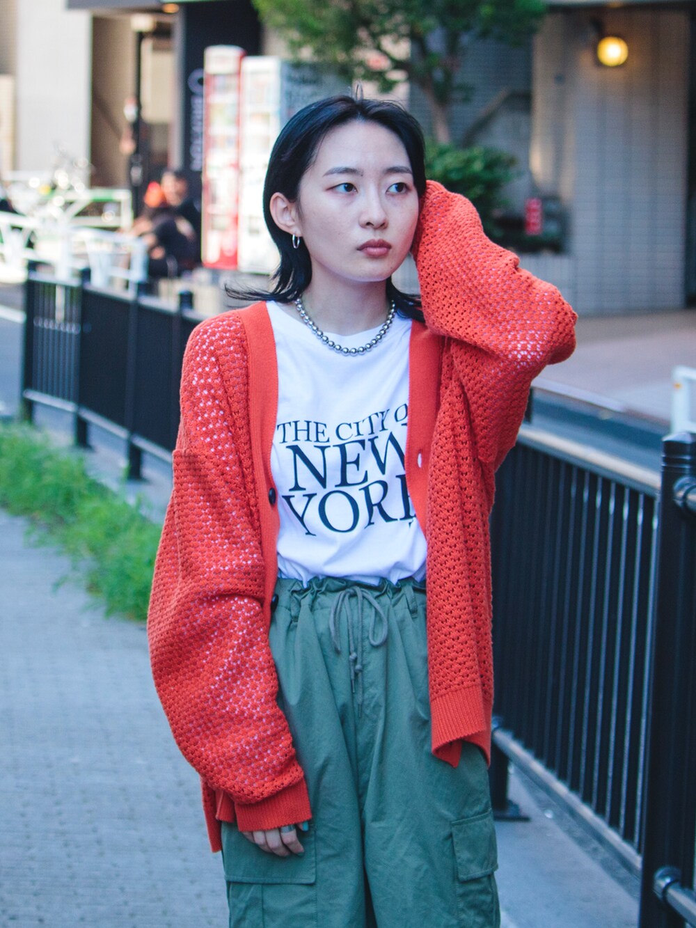 オレンジ系のカーディガン/ボレロ、ホワイト系のTシャツ/カットソーを着用したレディースの夏コーディネートの2枚目の写真