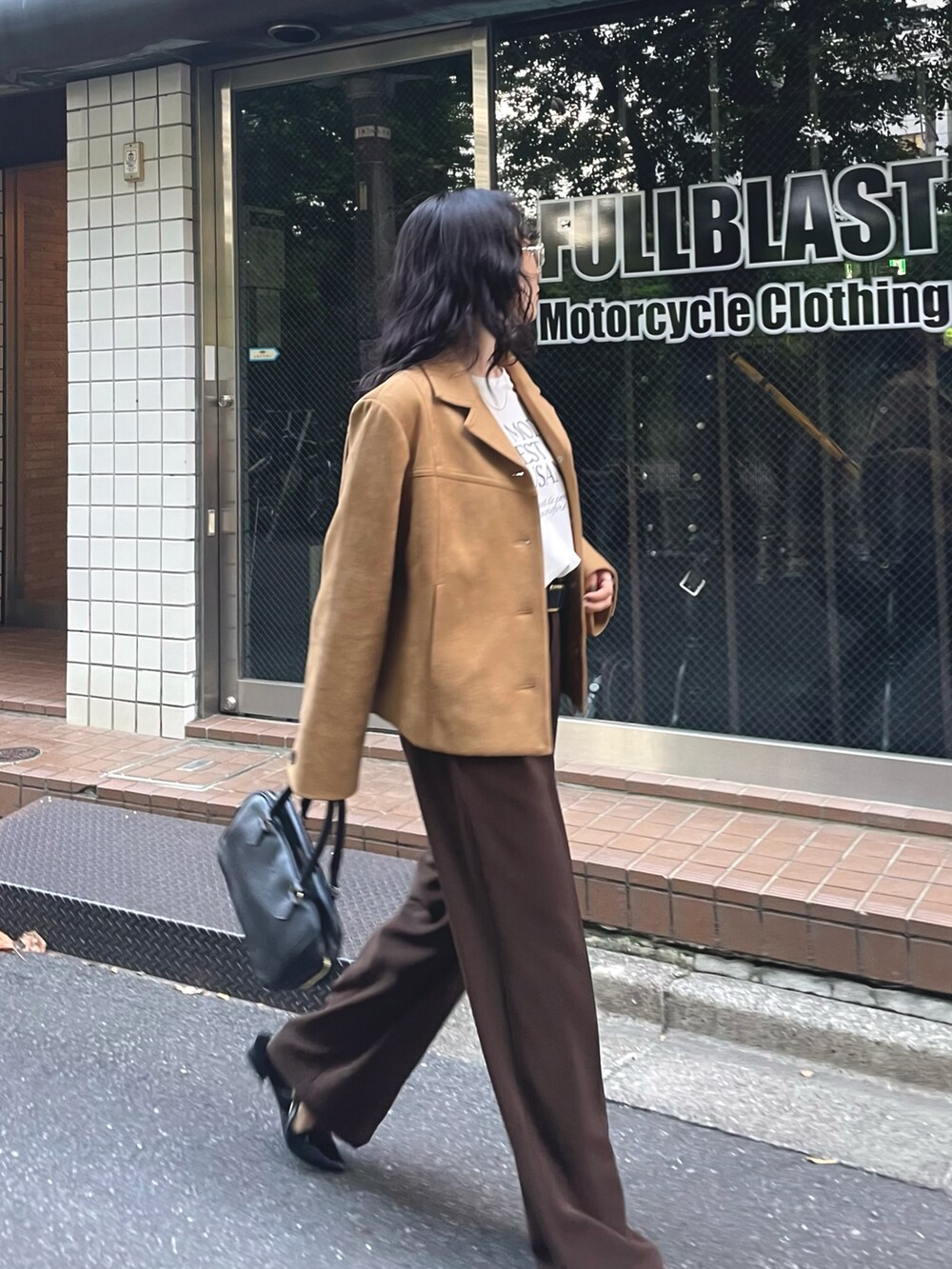 ベージュ系のダウンジャケット/コート、ホワイト系のTシャツ/カットソー、ブラウン系のスラックスを着用したレディースの秋コーディネートの7枚目の写真
