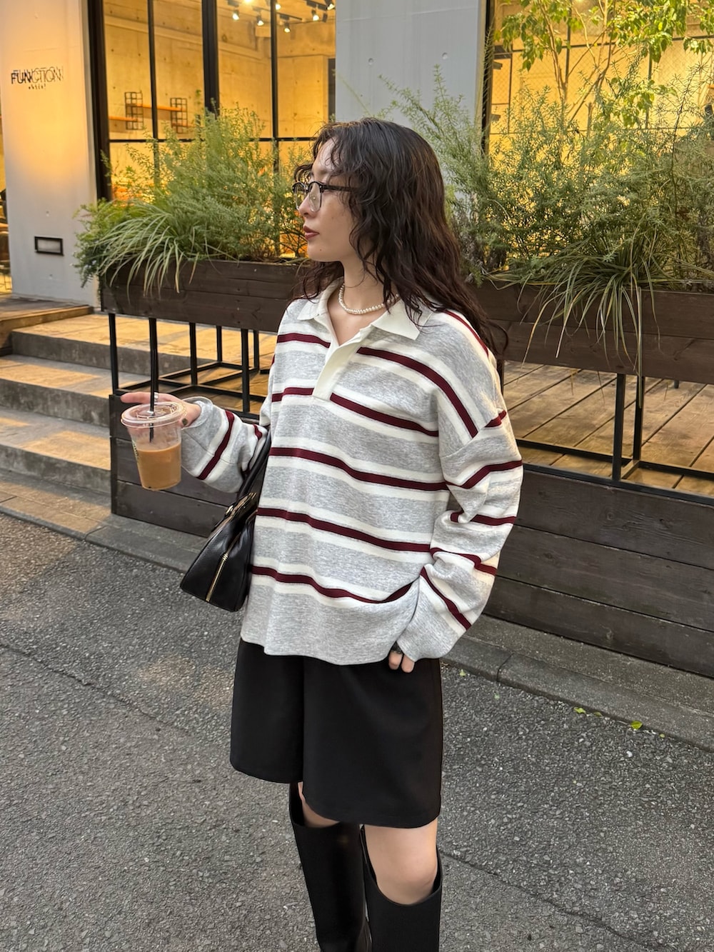 グレー系のニット/セーター、ブラック系のショルダーバッグを着用したレディースの秋コーディネートの5枚目の写真