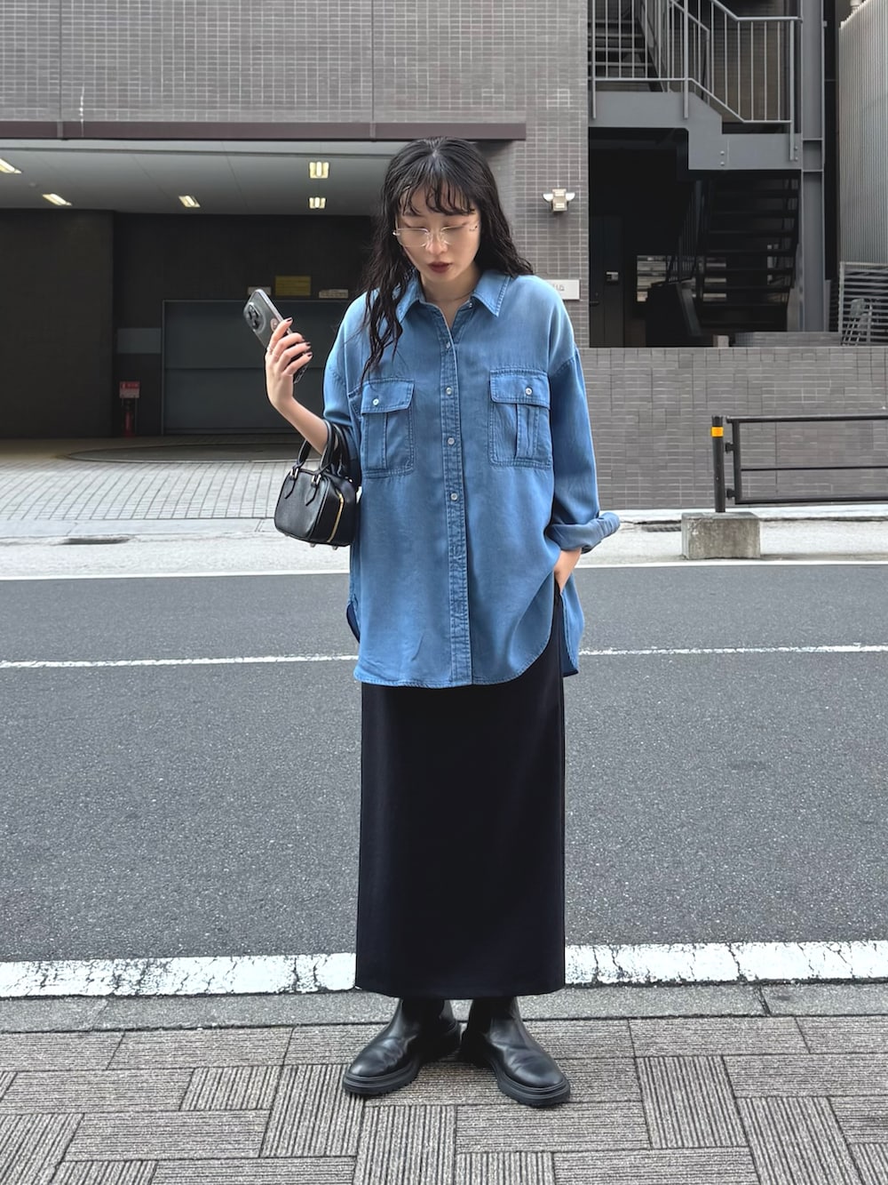 ブルー系のシャツ/ブラウス、ブラック系のスカートを着用したレディースの春コーディネートの6枚目の写真