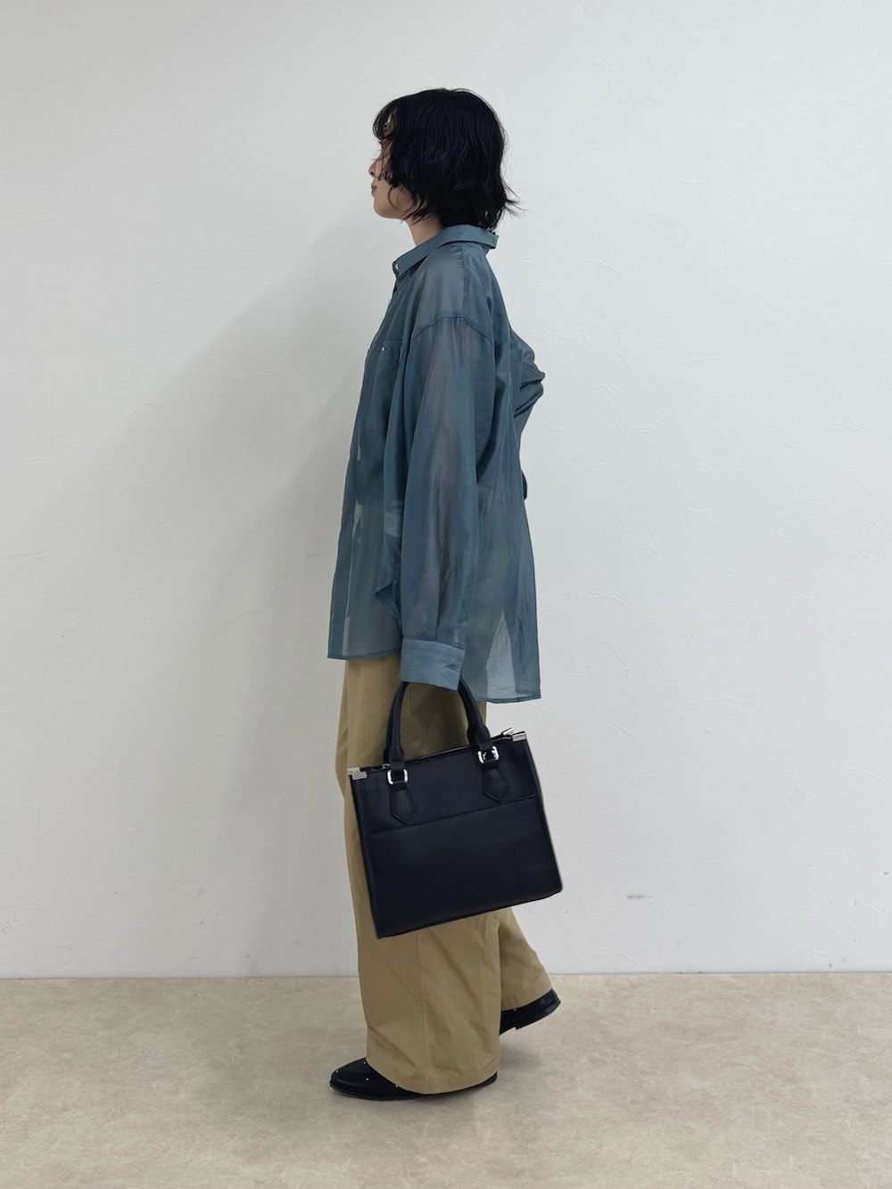 ベージュ系のその他パンツ、ブラック系のボストンバッグ、ブルー系のシャツ/ブラウスを着用したレディースの夏コーディネートの2枚目の写真