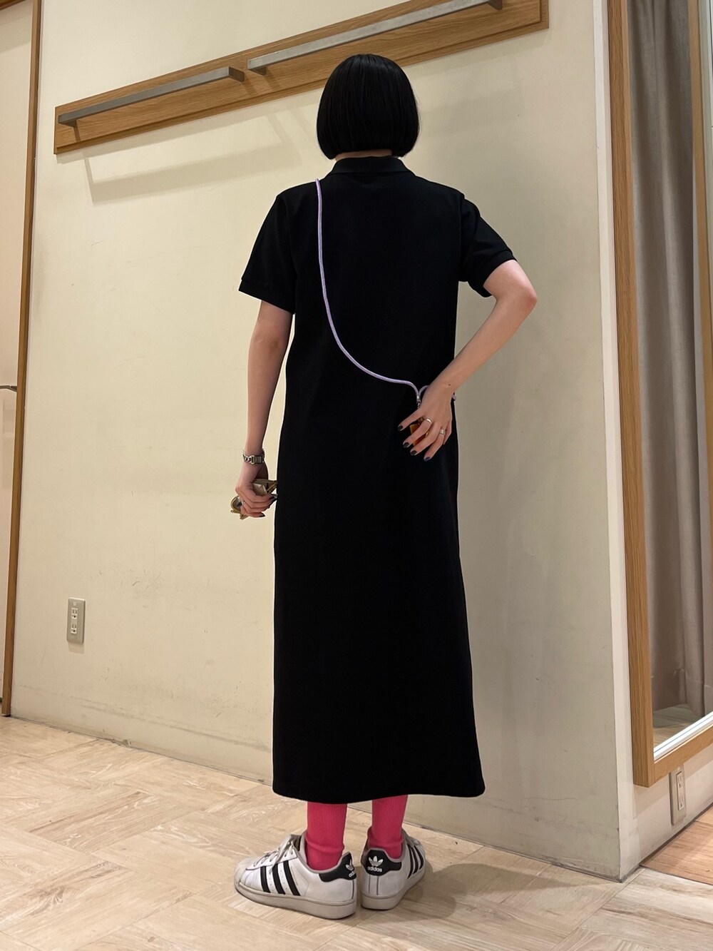 ブラック系のワンピース、パープル系のスマホグッズ、ベージュ系のサングラスを着用したレディースの春コーディネートの2枚目の写真