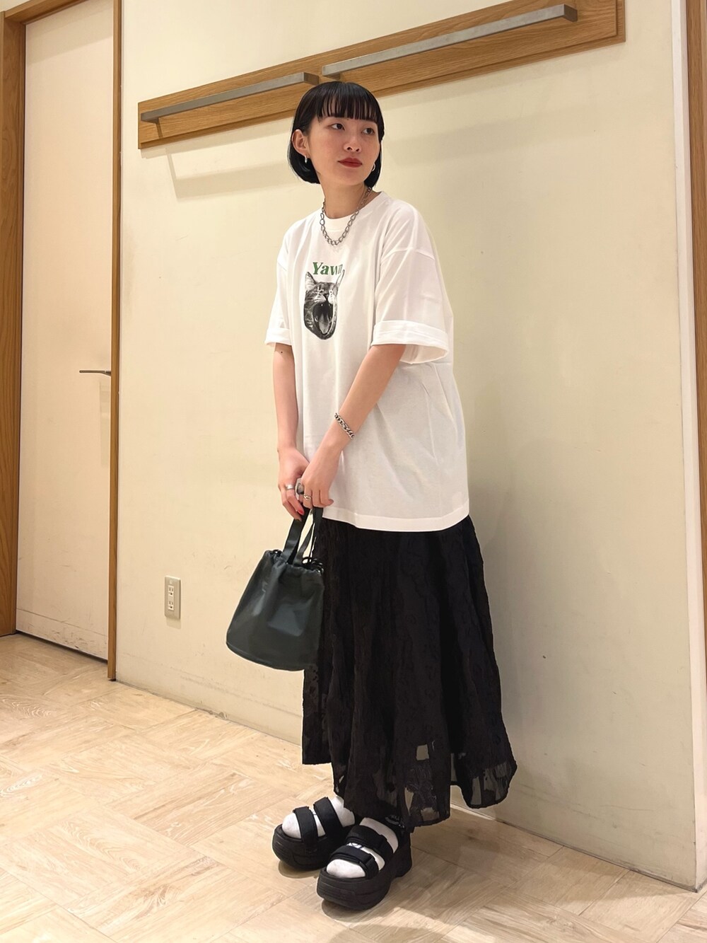 ホワイト系のTシャツ/カットソー、ブラック系のスカート、グレー系のショルダーバッグを着用したレディースの夏コーディネートの3枚目の写真