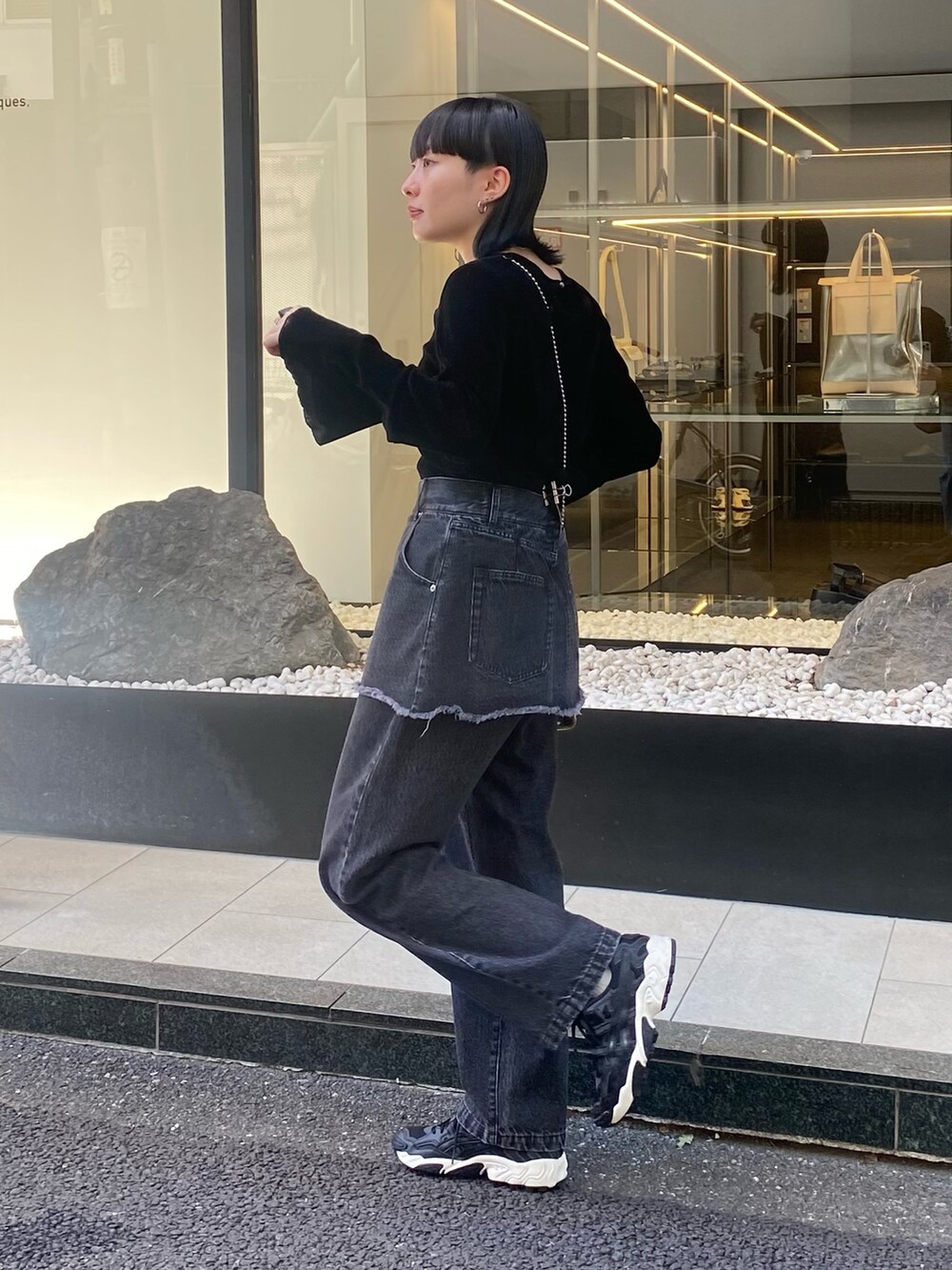 ブラック系のTシャツ/カットソー、ブラック系のデニムパンツを着用したレディースの秋コーディネートの2枚目の写真