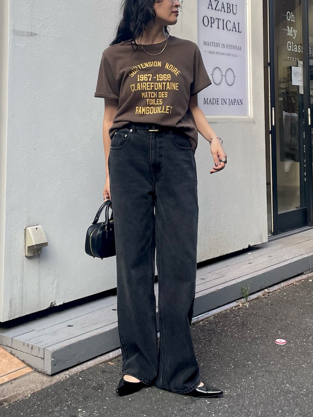 ブラウン系のTシャツ/カットソー、ブラック系のデニムパンツ、ブラック系のショルダーバッグを着用したレディースの夏コーディネートの6枚目の写真