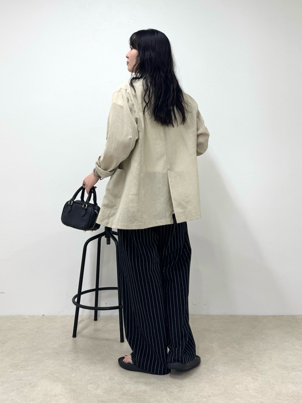 ブラック系のその他パンツ、ブラック系のサンダル、ホワイト系のTシャツ/カットソーを着用したレディースの春コーディネートの2枚目の写真