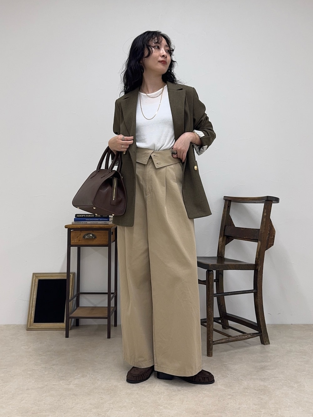 ブラウン系のテーラードジャケット、ホワイト系のTシャツ/カットソー、ベージュ系のチノパンツを着用したレディースの秋コーディネートの3枚目の写真