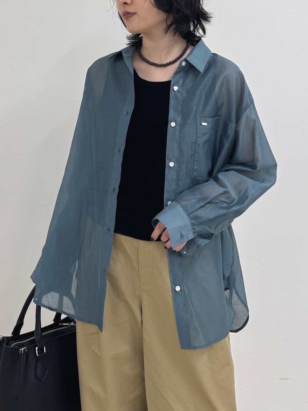 ベージュ系のその他パンツ、ブラック系のボストンバッグ、ブルー系のシャツ/ブラウスを着用したレディースの夏コーディネートの4枚目の写真