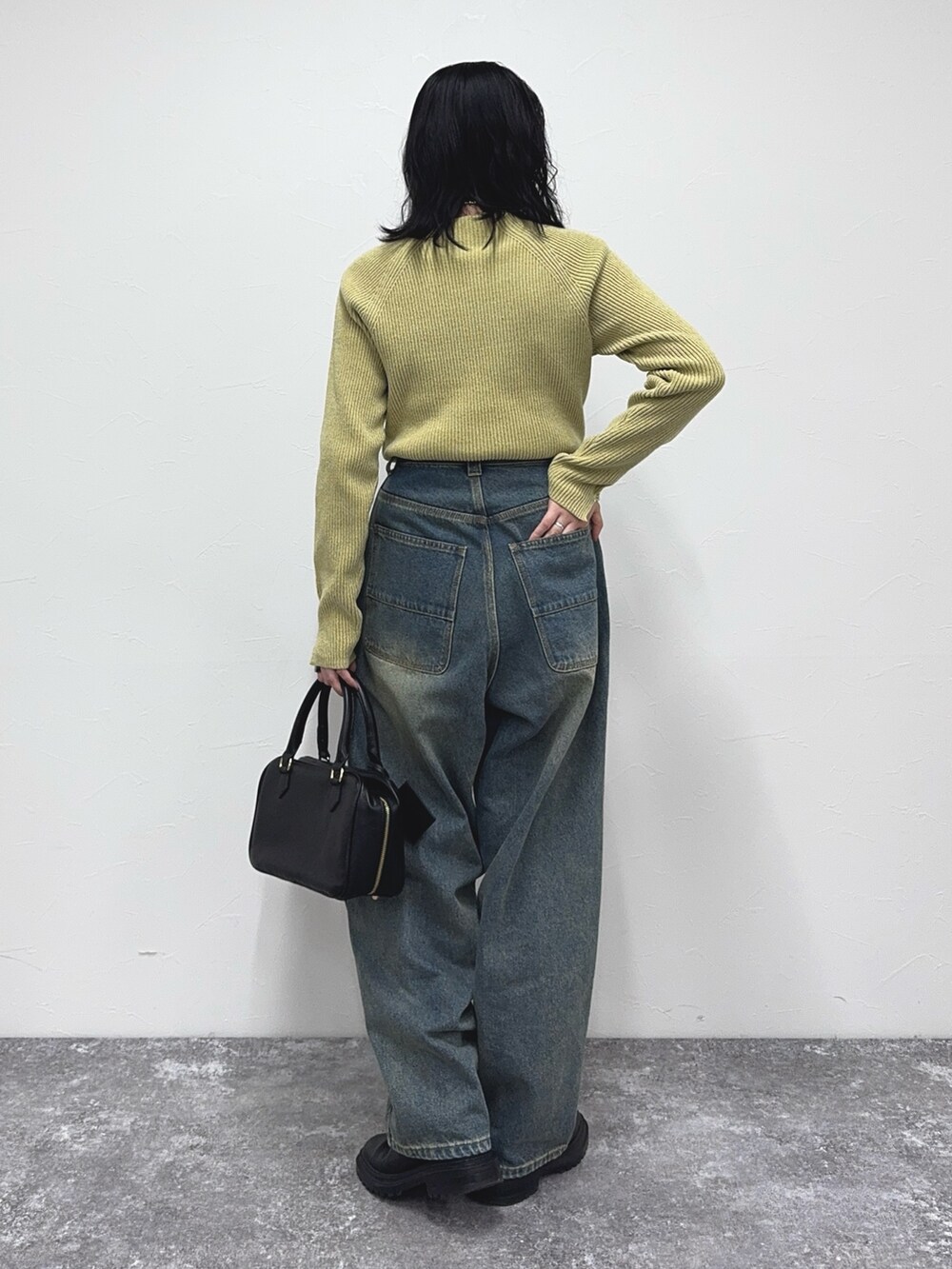 イエロー系のその他トップス、ブルー系のデニムパンツを着用したレディースの冬コーディネートの4枚目の写真