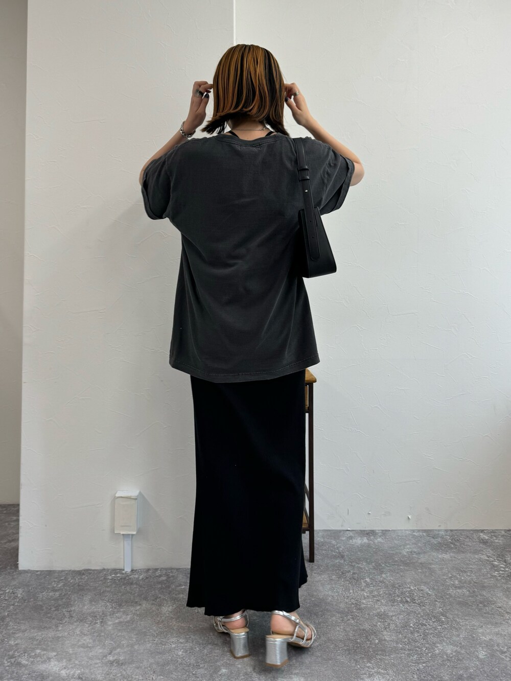 ブラック系のスカート、シルバー系のサンダル、グレー系のTシャツ/カットソーを着用したレディースの夏コーディネートの3枚目の写真