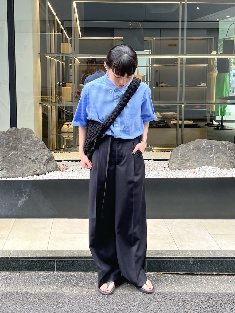 ブルー系のシャツ/ブラウス、ブラック系のサンダル、ブラック系のスラックスを着用したレディースの夏コーディネートの2枚目の写真