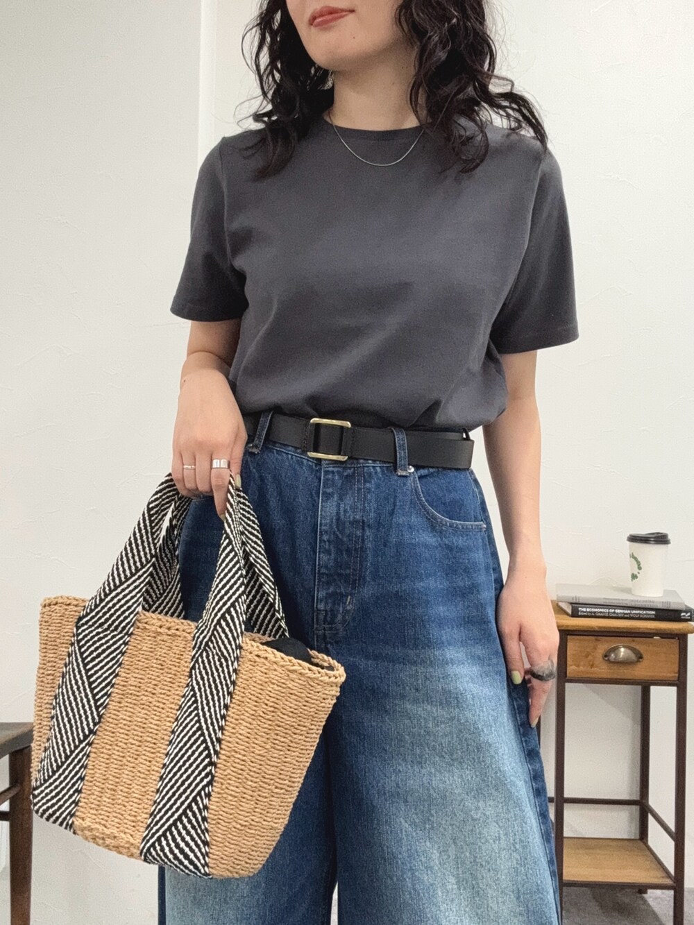 グレー系のTシャツ/カットソー、ブルー系のデニムパンツ、ベージュ系のかごバッグを着用したレディースの夏コーディネートの6枚目の写真