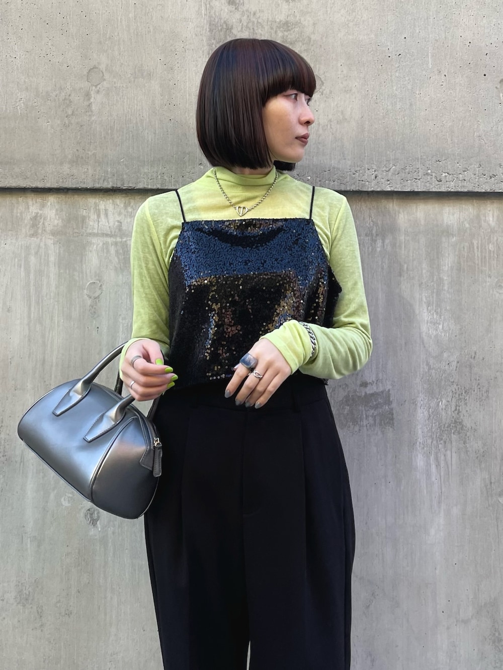 ブラック系のシャツ/ブラウス、グリーン系のトップス、ブラック系のスラックスを着用したレディースの冬コーディネートの4枚目の写真