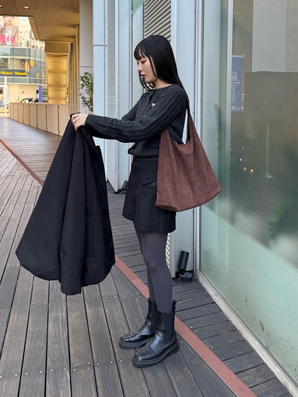 ブラック系のダッフルコート、グレー系のニット/セーターを着用したレディースの秋コーディネートの4枚目の写真