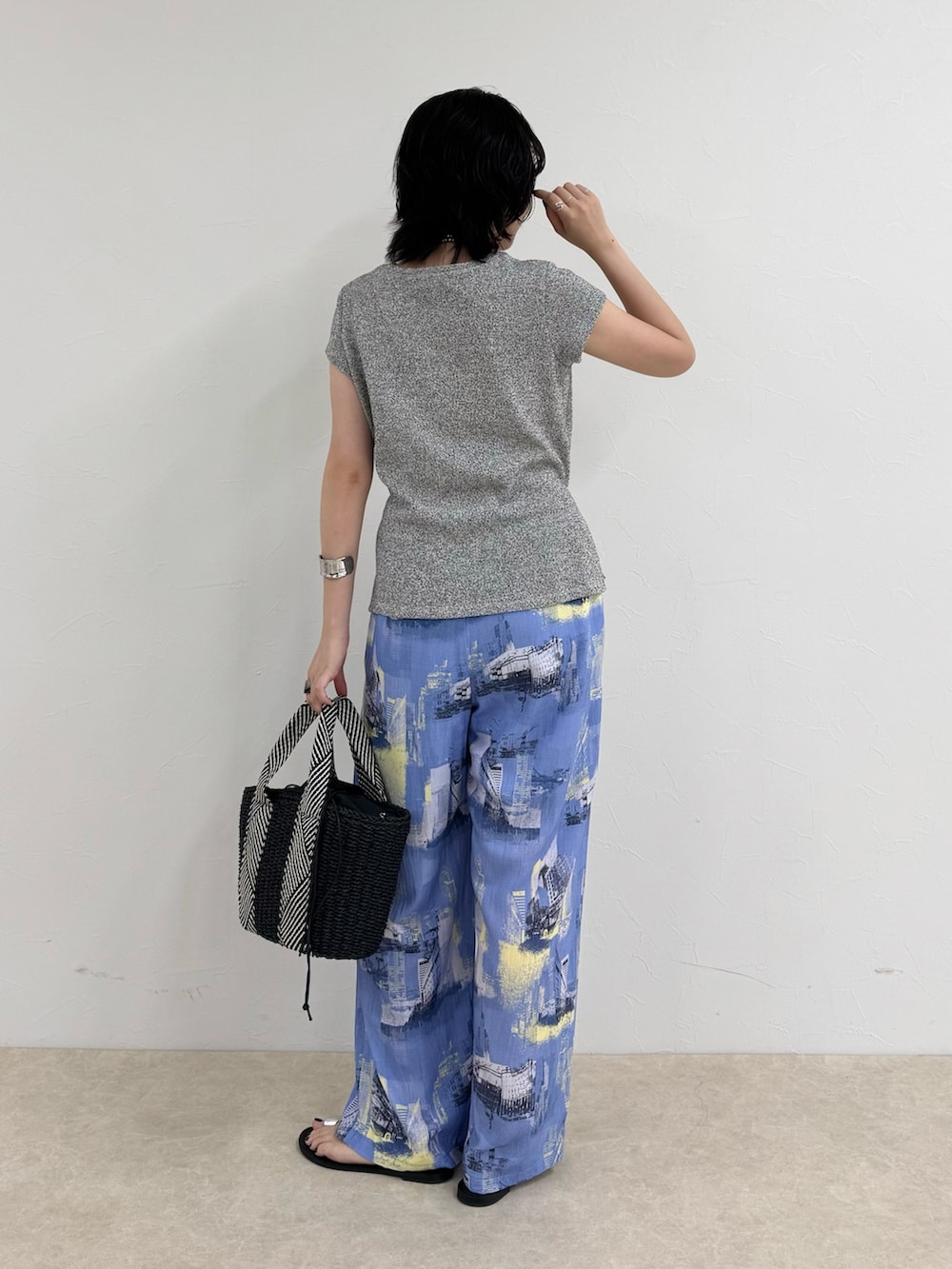 ブルー系のその他パンツ、ブラック系のかごバッグ、グレー系のTシャツ/カットソーを着用したレディースの夏コーディネートの3枚目の写真