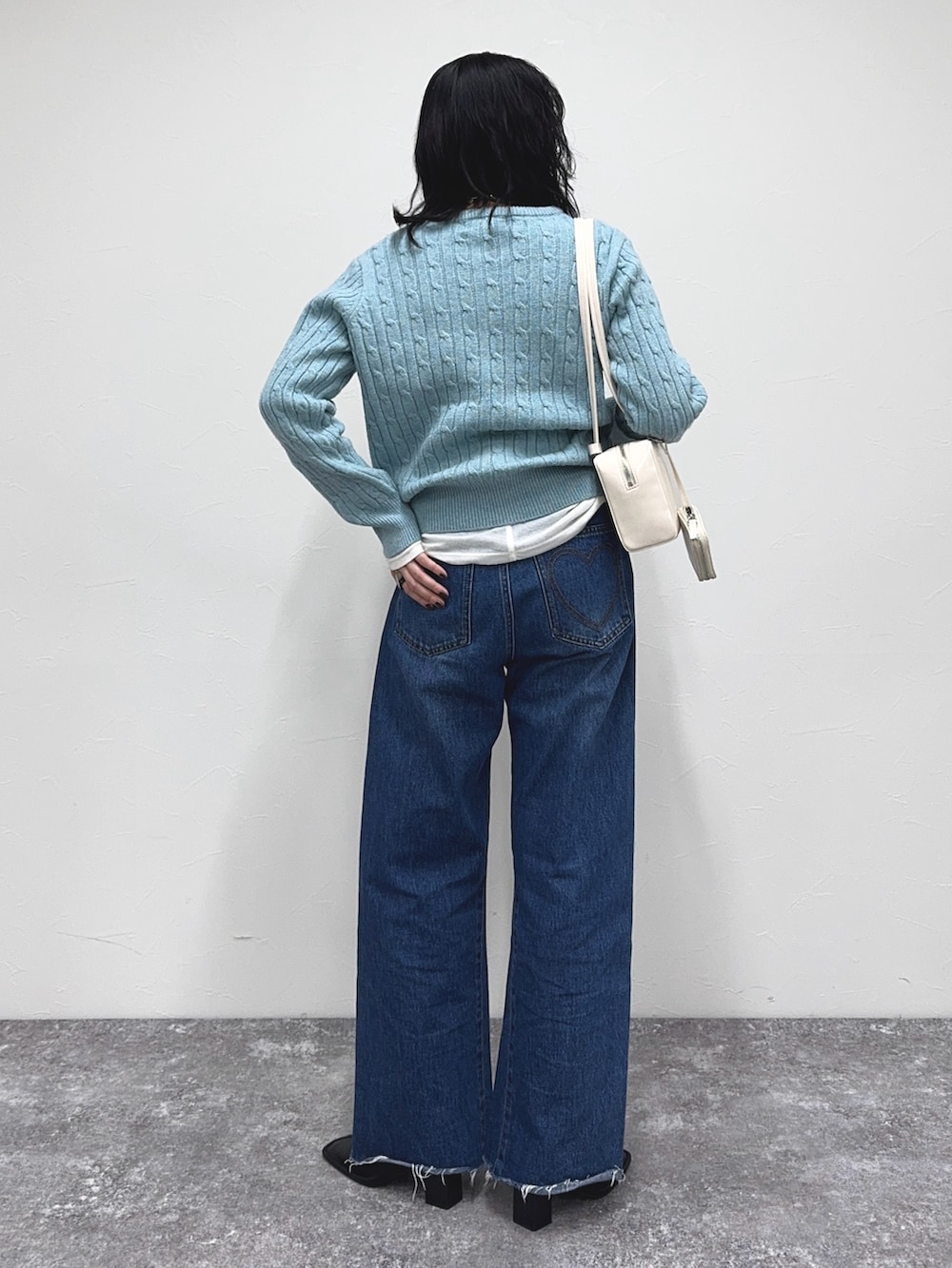 ブルー系のニット/セーター、ブルー系のデニムパンツ、ホワイト系のTシャツ/カットソーを着用したレディースの冬コーディネートの5枚目の写真