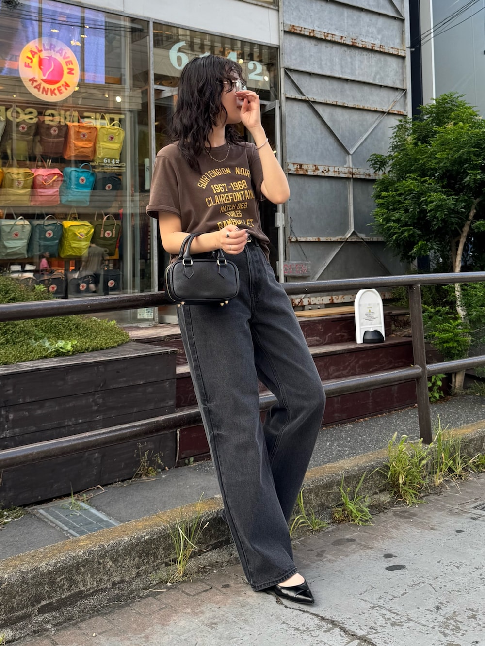 ブラウン系のTシャツ/カットソー、ブラック系のデニムパンツ、ブラック系のショルダーバッグを着用したレディースの夏コーディネートの5枚目の写真