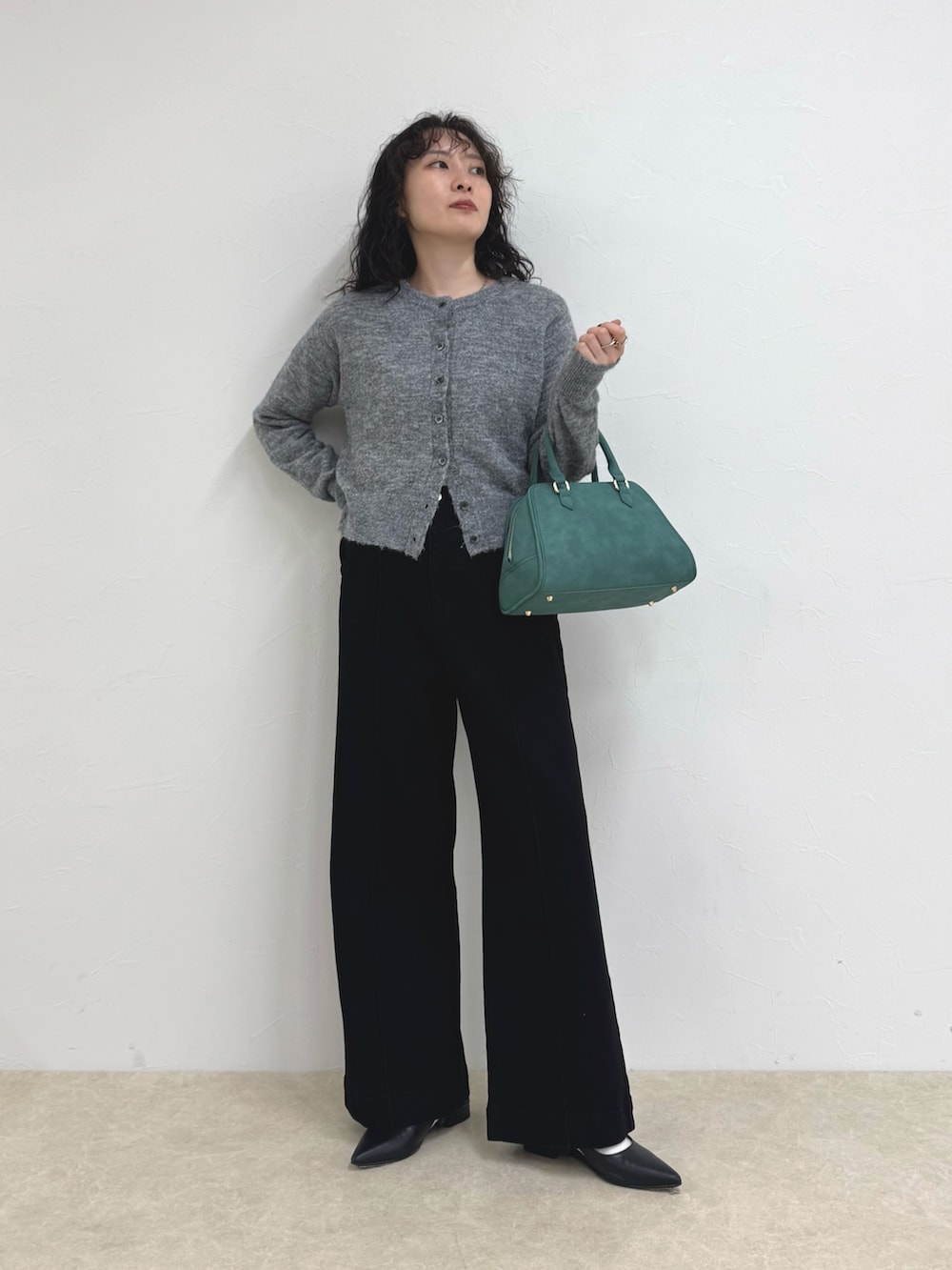 グレー系のカーディガン/ボレロ、グリーン系のショルダーバッグ、ブルー系のデニムパンツを着用したレディースの秋コーディネートの3枚目の写真