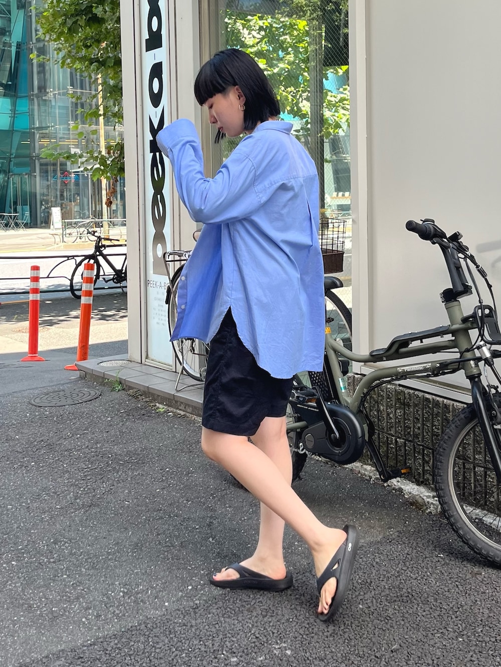 ブルー系のシャツ/ブラウス、ブラック系のサンダル、ブラック系のショルダーバッグを着用したレディースの秋コーディネートの2枚目の写真