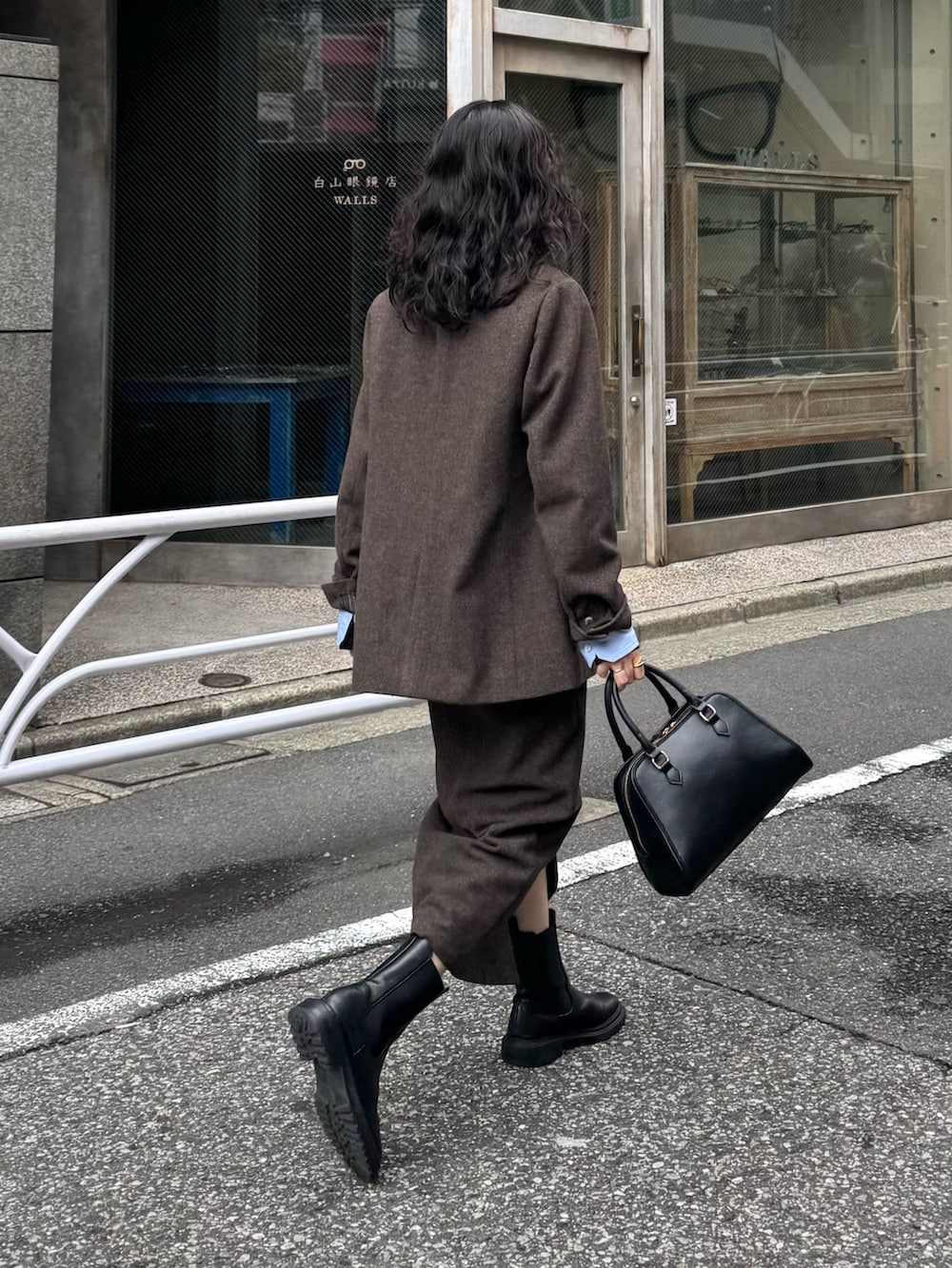 ブラウン系のテーラードジャケット、ブルー系のシャツ/ブラウス、ブラウン系のスカートを着用したレディースの秋コーディネートの3枚目の写真