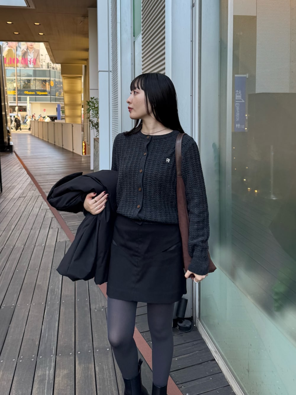 ブラック系のダッフルコート、グレー系のニット/セーターを着用したレディースの秋コーディネートの5枚目の写真