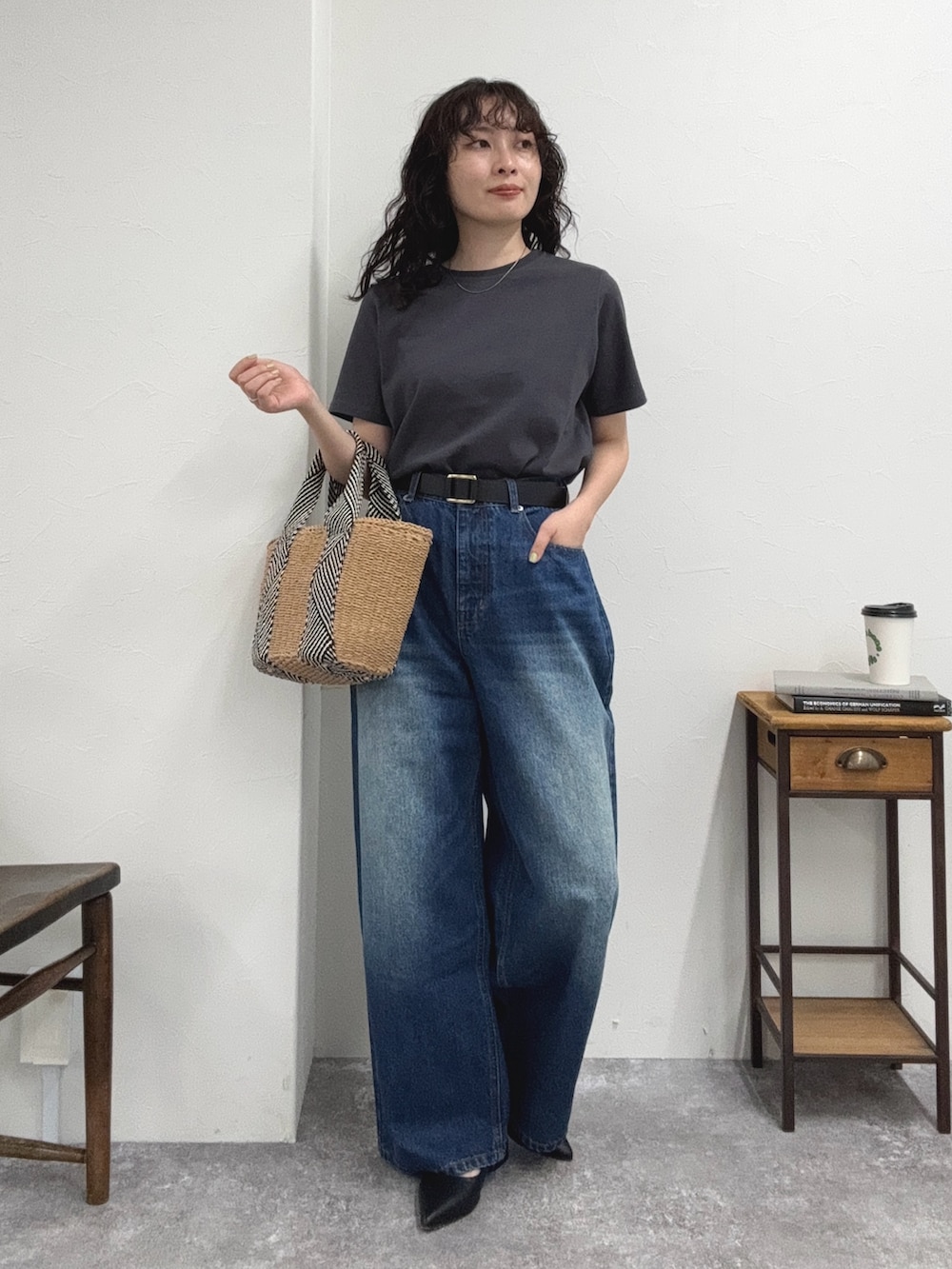 グレー系のTシャツ/カットソー、ブルー系のデニムパンツ、ベージュ系のかごバッグを着用したレディースの夏コーディネートの2枚目の写真